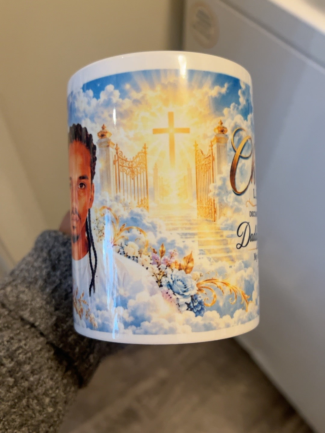 Mug-only side showing golden gates, cross and clouds between portrait and memorial message